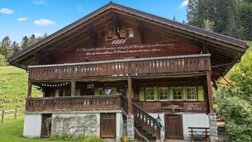 Ein traditionelles Holzchalet mit Balkon und Treppe, mit einem Schild, das das Jahr 1861 angibt.
