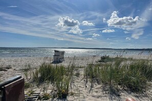 A beach with a clear sky, a body of water, and a wooden structure in the foreground. - Holiday apartment with 1 bedroom (Glücksburg)