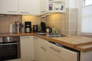 A kitchen with a stove, oven, coffee maker, and a sink. - Holiday apartment in Sylt with 3 bedrooms (Westerland\/ Sylt)