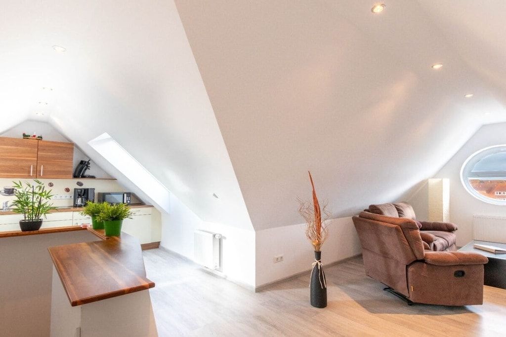 Un appartement moderne de style « loft », comprenant une cuisine, un coin salon et une grande verrière.