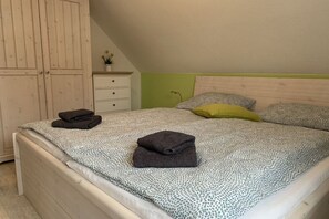 A bedroom with a bed, a nightstand, and a wardrobe. - Holiday home with 3 bedrooms (Wangerland \/ Hooksiel)