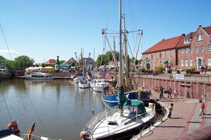 Ein Hafen mit vertäuten Booten, ein Gebäude mit rotem Dach und ein klarer Himmel.