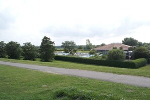 Ein Rasen mit einem gepflasterten Weg, der zu einem Gebäude mit einem Schwimmbad führt.