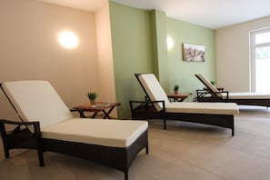 A room with three wicker lounge chairs, a small table with a plant, and a wall-mounted picture. - Villa Louisa 46 - Störtebeker (Ostseebad Sellin)