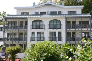 Un immeuble à plusieurs étages doté de balcons et de grandes fenêtres.