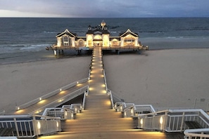 A pier leading to a building with a dome on top, overlooking the ocean. - Villa Louisa 35 - Sellinperle (Ostseebad Sellin)