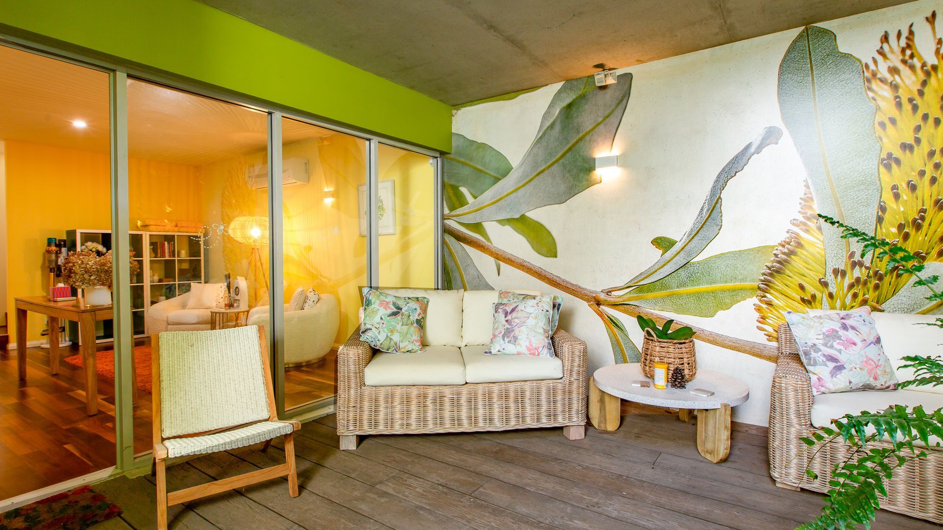 Un salon moderne avec un canapé, des fauteuils, une petite table et une grande fresque murale.