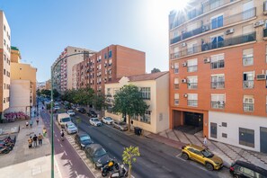 A multi-story urban street with parked cars and a pedestrian walkway. - Cubo's Espronceda Malaga Apartment / urban / air conditioning / free wifi (Málaga)