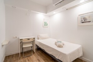 A small, clean room with a single bed, a desk, and a chair. - Cubo's Espronceda Malaga Apartment / urban / air conditioning / free wifi (Málaga)