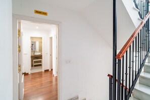 A staircase with a black handrail and white steps, leading to an upper floor. - Cubo's Montaño Malaga Apartment / near beach / urban / air conditioning / free wifi (Málaga)