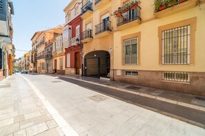 Eine Straße gesäumt von bunten Gebäuden, ein klarer Himmel und ein Fußweg.