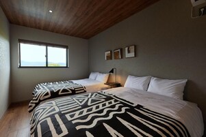 Un dormitorio con una cama grande, una cama más pequeña y un ventanal con vistas.