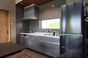 Una cocina moderna con estufa integrada, electrodomésticos de acero inoxidable y un ventanal grande.