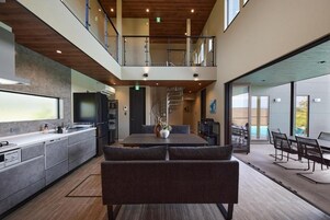 Una cocina moderna con comedor, una escalera y vistas al exterior.