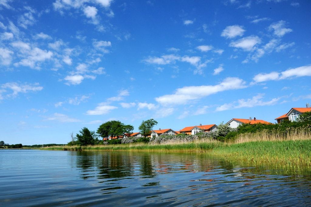 Vista de un lago con casas y un cielo despejado.
