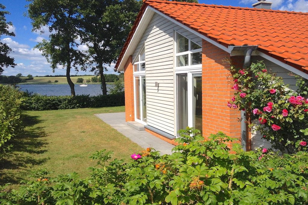 A house with a red roof, a brick exterior, and a large window.