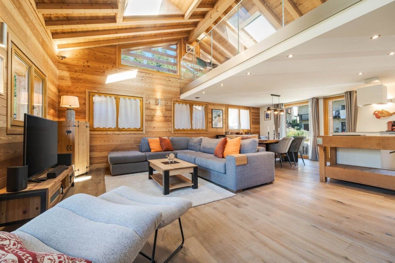 Een modern interieur met een houten plafond, een zithoek, een televisie en een eethoek.