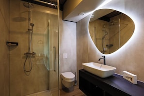A modern bathroom with a glass-enclosed shower, a toilet, and a vanity with a large mirror. - Spacious and comfortable Studio for 2 persons (Midsland)