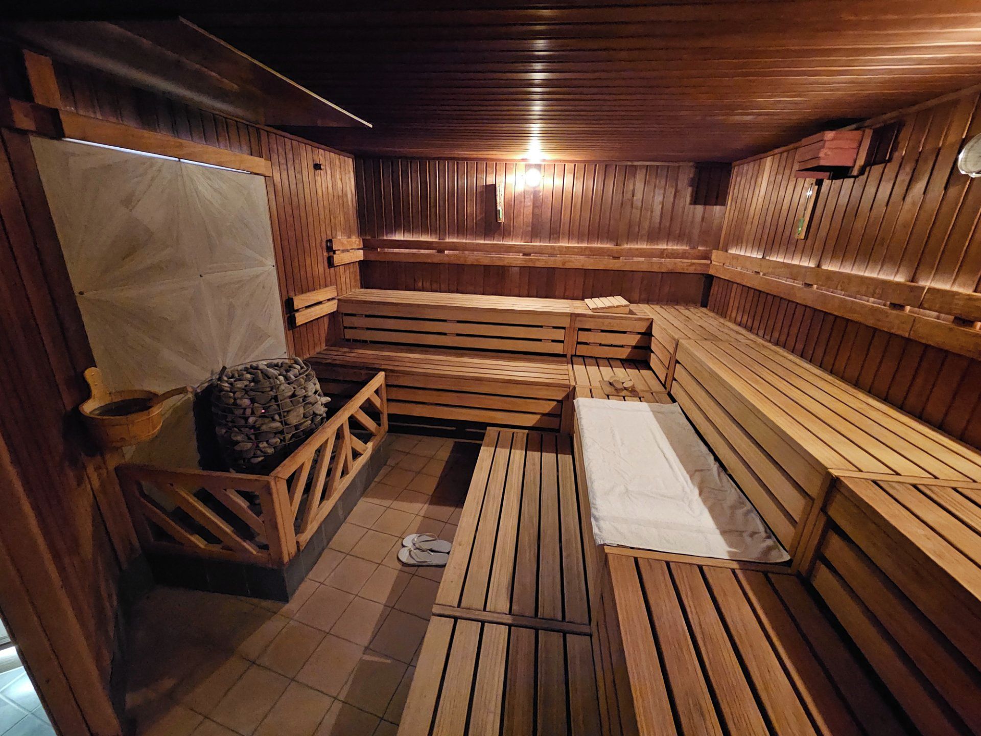Eine Sauna mit Holzbänken und einem Steinkamin.
