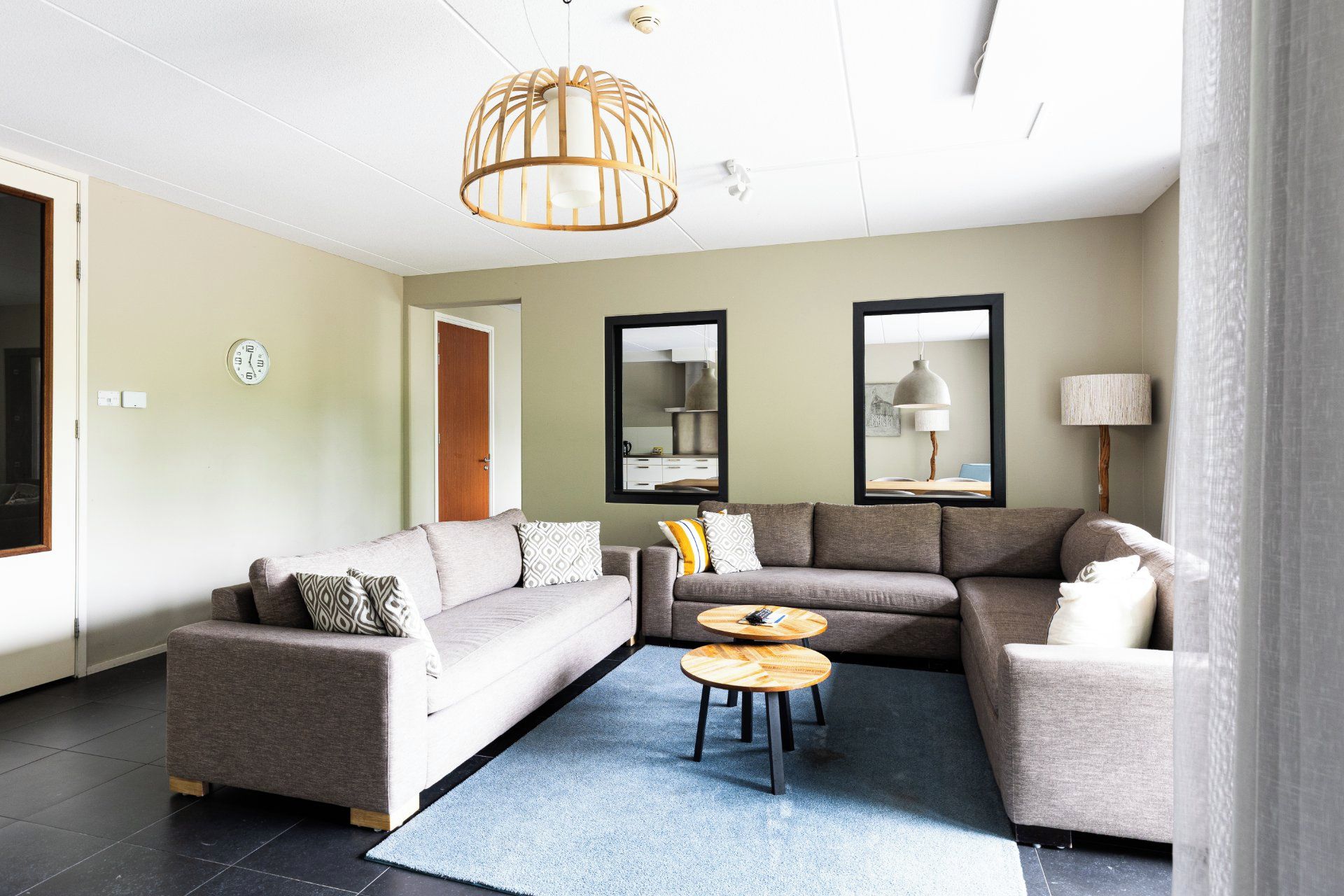 Ein modernes Wohnzimmer mit einer Eckcouch, einem Couchtisch und einer Pendelleuchte.