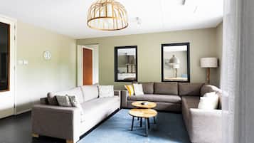 Ein modernes Wohnzimmer mit einer Eckcouch, einem Couchtisch und einer Pendelleuchte.