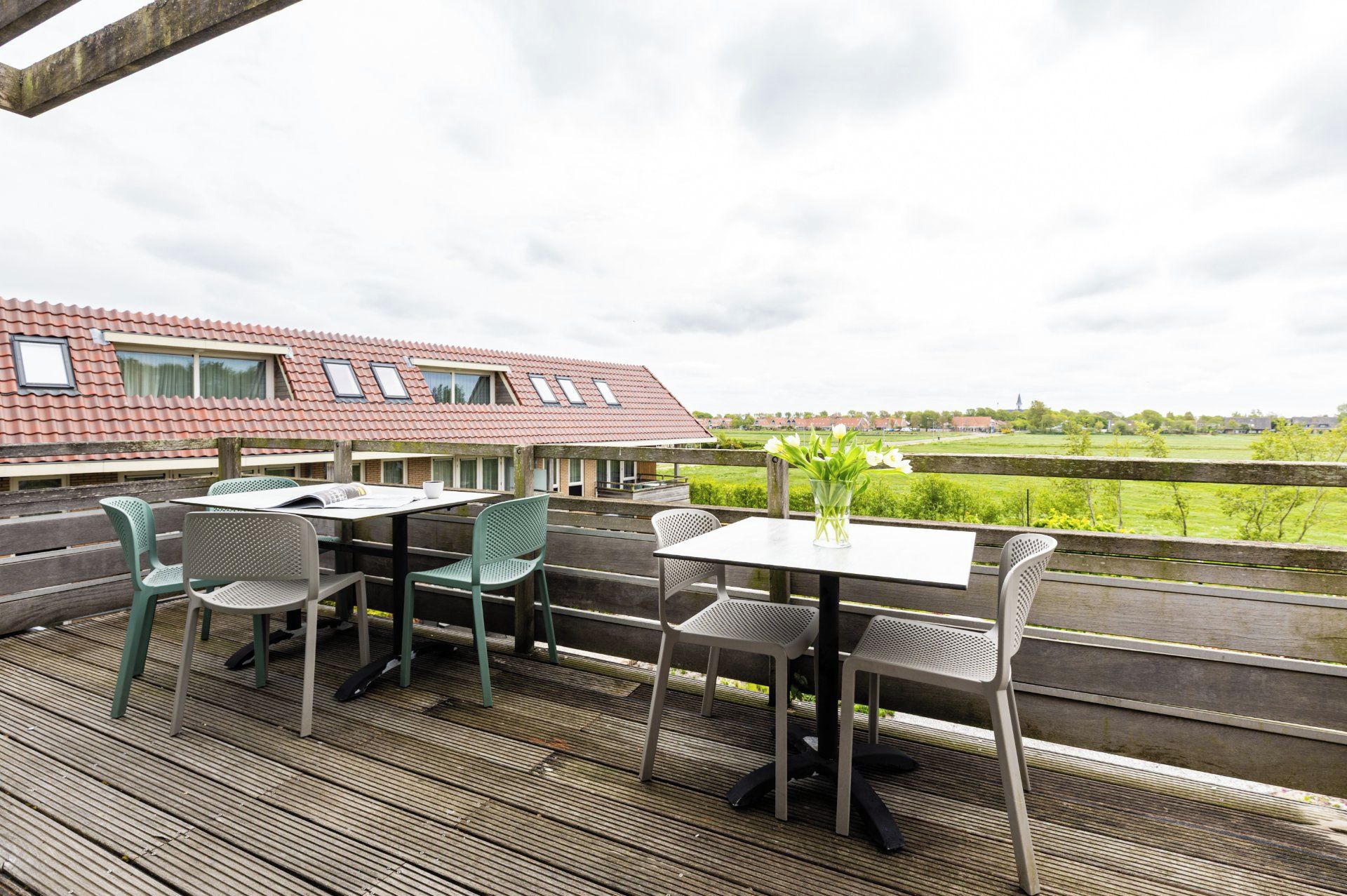 Une terrasse extérieure avec une table et des chaises, donnant sur un paysage rural.