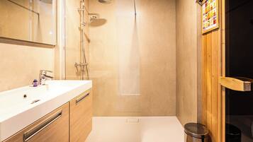 A modern bathroom with a shower, a sink, and a toilet.