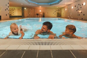 An indoor swimming pool with three people in the water. - This pleasant 5 person Wellness Apartment with three bedrooms and private sauna is exactly what you are looking for! (Midsland)