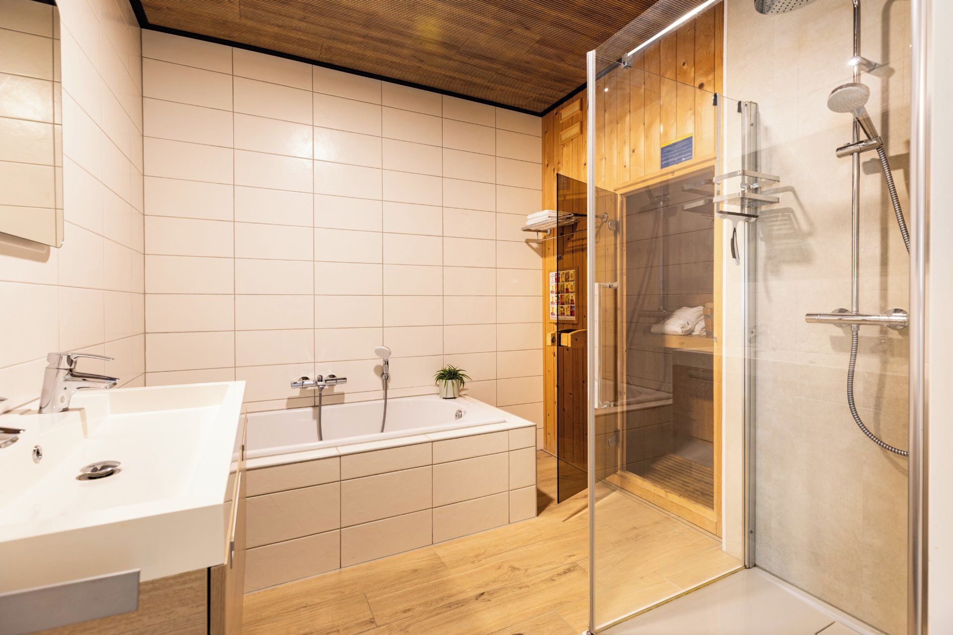 A modern bathroom with a bathtub, a glass-enclosed shower, and a wooden vanity.