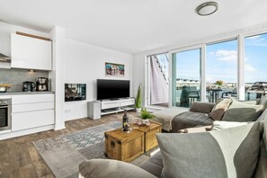 A modern living room with a flat-screen TV, a wooden coffee table, and a sofa. - Houseboat in Olpenitz with swimming pool (Olpenitz)