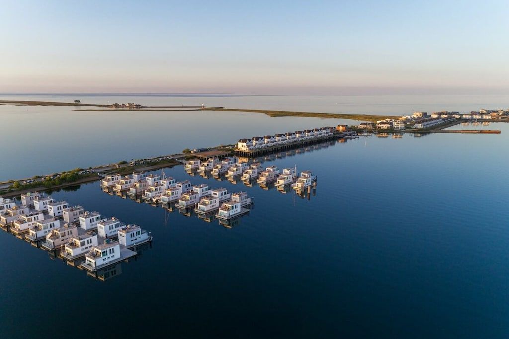 A waterfront property with floating houses connected by a pier.