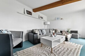 Un salon moderne avec un canapé, une table basse et une lampe.