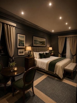 Een hotelkamer met een bed, nachtkastjes, een stoel, een klein tafeltje en gordijnen.