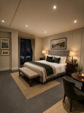 Een hotelkamer met een bed, nachtkastjes, een bankje, een stoel, een tafeltje en uitzicht op het exterieur.