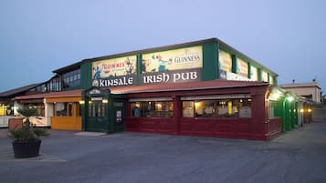 Un pub con anuncios de Guinness y un letrero que indica 'Kinsale Irish Pub'.