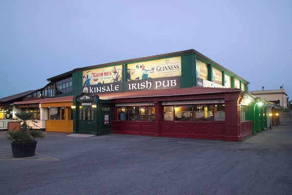 Un pub con anuncios de Guinness y un letrero que indica 'Kinsale Irish Pub'.