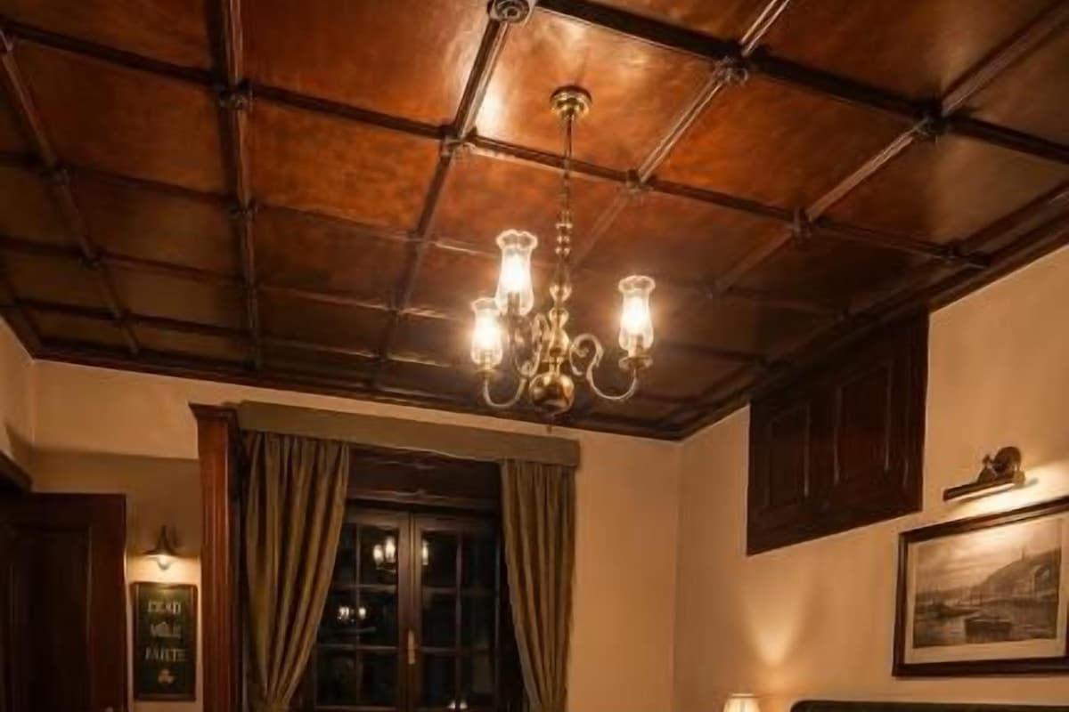 Een klassieke kamer met een groot bed, houten vloeren, een kroonluchter en een raam met gordijnen.