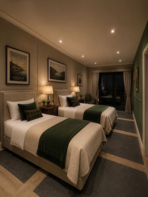 Habitación de hotel con dos camas, vistas de la ciudad y un cuadro enmarcado de Kinsale en la pared.