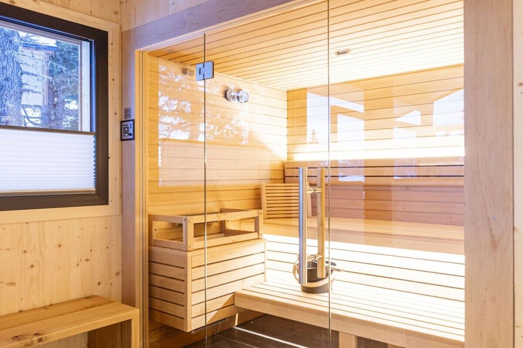 Una sauna con bancos de madera y una pared de cristal.