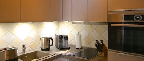 Una cocina moderna equipada con cafetera, hervidor y tostadora.