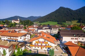 A town with traditional architecture, including a church with a bell tower, surrounded by residential buildings with red-tiled roofs. - Holiday apartment with 2 bedrooms (Ruhpolding)