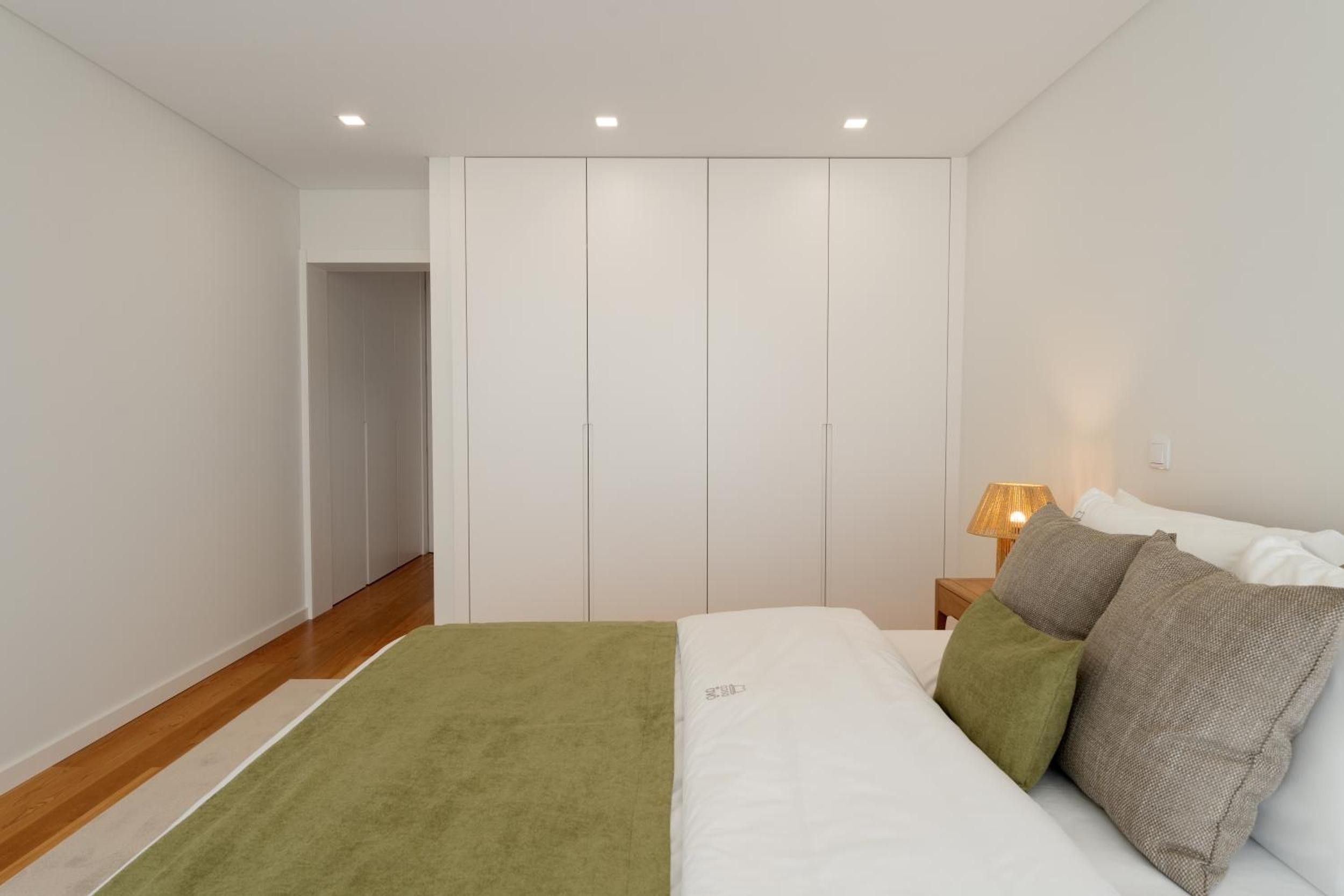 Une chambre à coucher avec un lit, une table de chevet, une lampe et une armoire.