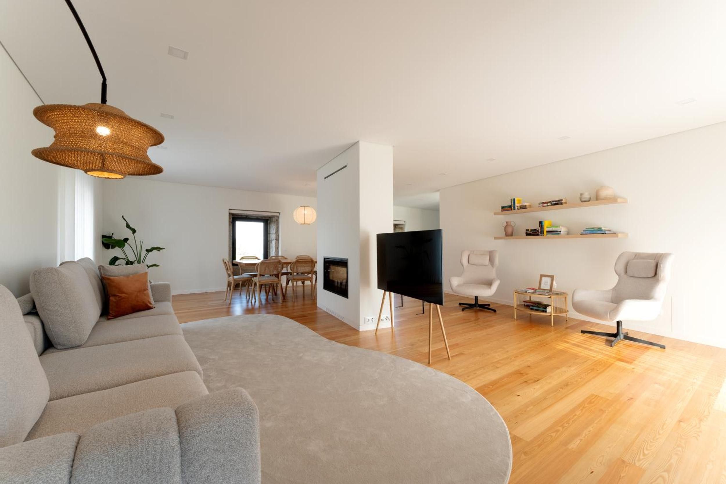 A modern living room with a sofa, TV, and wooden flooring.