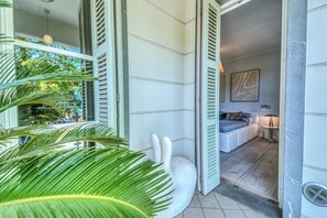 A modern interior with a large window, a white sculpture, and a bed with a blue headboard. - Casa Quarrata (Quarrata)