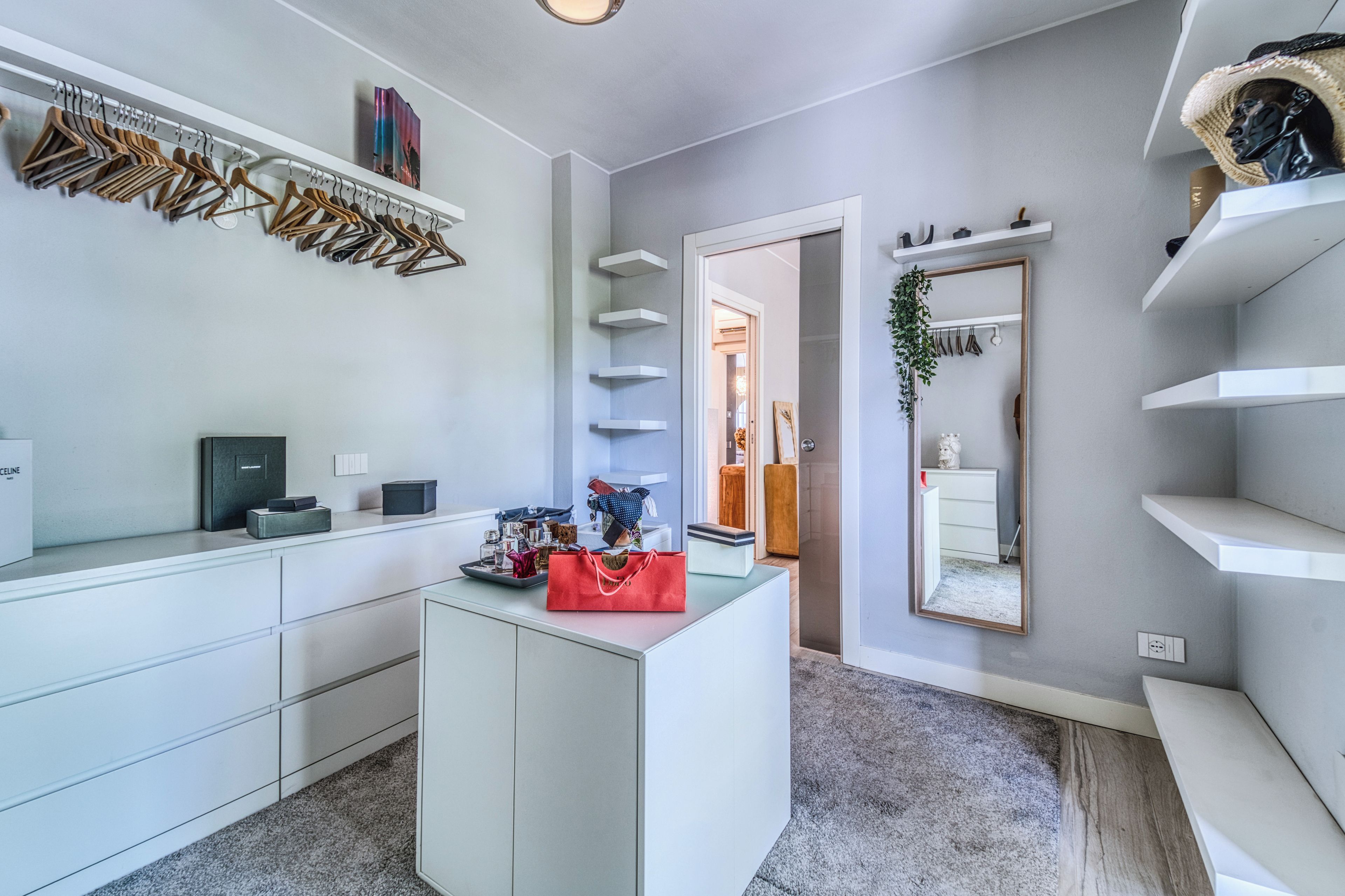A modern bathroom with a vanity, mirror, and towel rack.