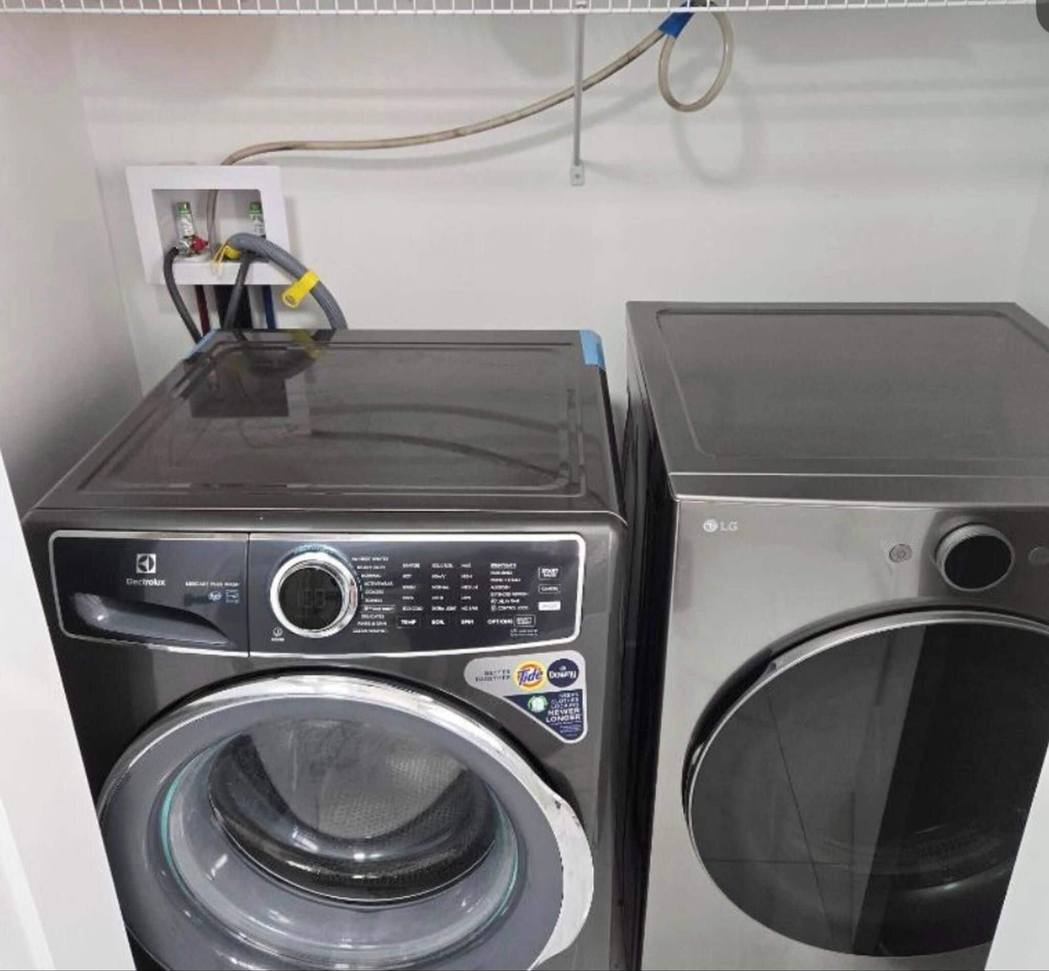 Two stacked washing machines in a utility room.