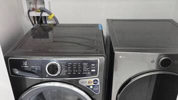 Two stacked washing machines in a utility room.
