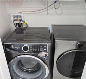 Two stacked washing machines in a utility room. - Stylish 3BR Home Near Moncton Airport Free Parking (Dieppe)