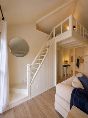 A staircase leading to a loft bedroom with a view of the living area below. - Luxury Loft |Sauna, Hot Tub & Peaceful BalconyView (Houston)
