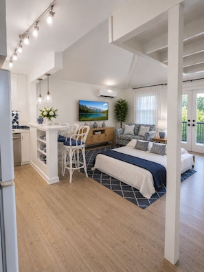A modern interior with a dining area, kitchen, and bedroom. - Luxury Loft |Sauna, Hot Tub & Peaceful BalconyView (Houston)